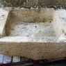 Long bac ancien de style lavoir avec rebords en pierre patinée